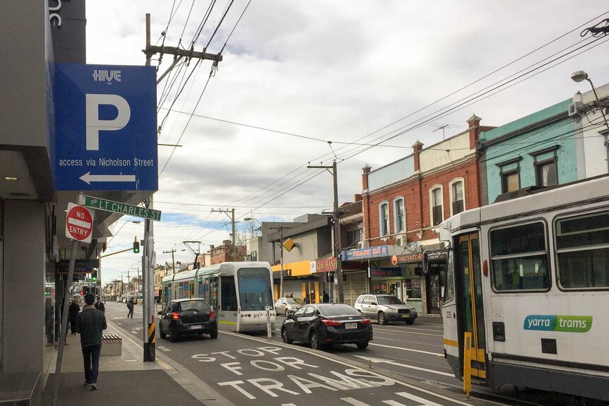 A street with trams and restaurants, sign to laneway reads "Lt Charles St".