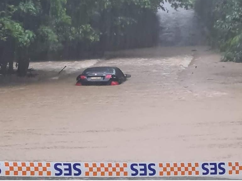 Car submerged in brown flood waters 