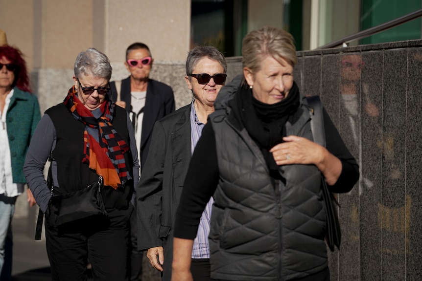 Person (Jan Cameron) walking into the Hobart Magistrates Court with group.