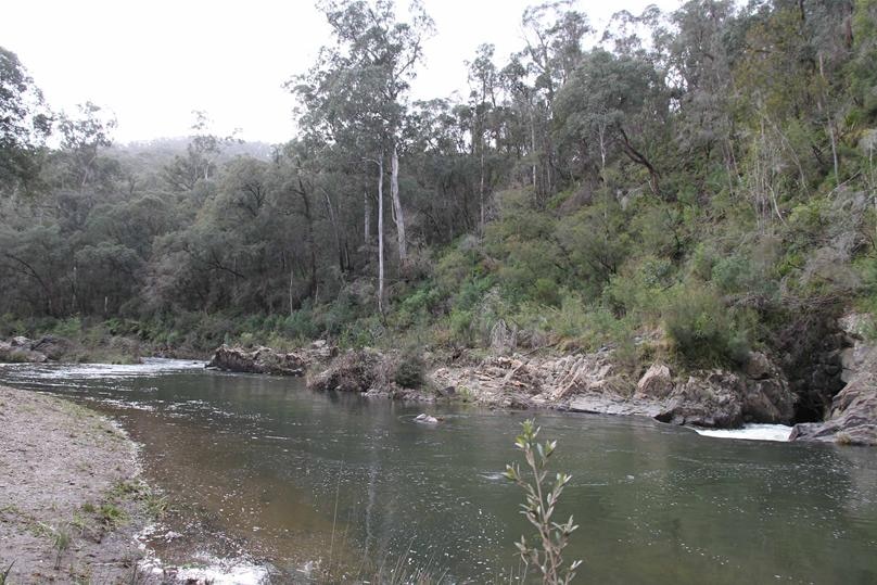 A waterway winding through tough-looking bushland.