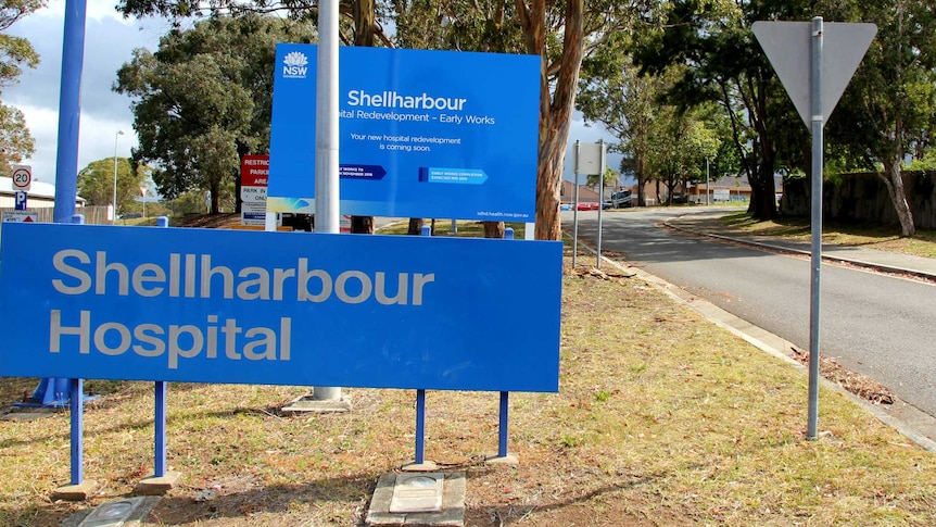 A blue sign with the name of the hospital - Shellharbour Hospital - at the front of the facility.