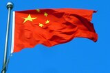 Chinese flag flying against a blue sky.
