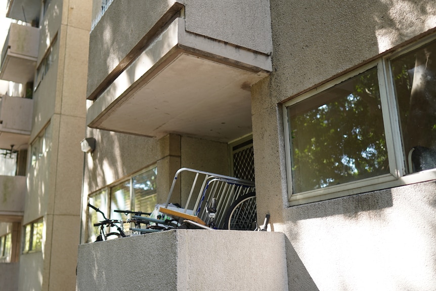 Bicycles piled up on an apartment balcony.