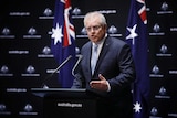 Scott Morrison speaks in front of a Government backdrop.