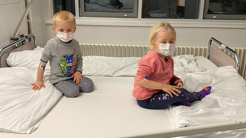 Frederick and Charlotte Rowley on a hospital bed wearing masks