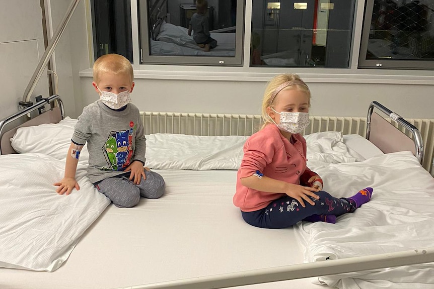 Charlotte and Freddie Rowley on a hospital bed wearing masks