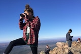 Girl with camera on top of mountain