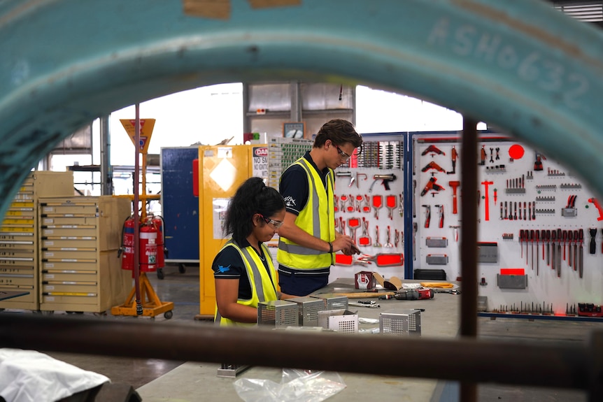 Young woman and man fixing airplane equipment