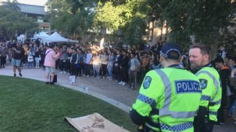 Police and Chinese students stand on the campus at the University of Queensland.
