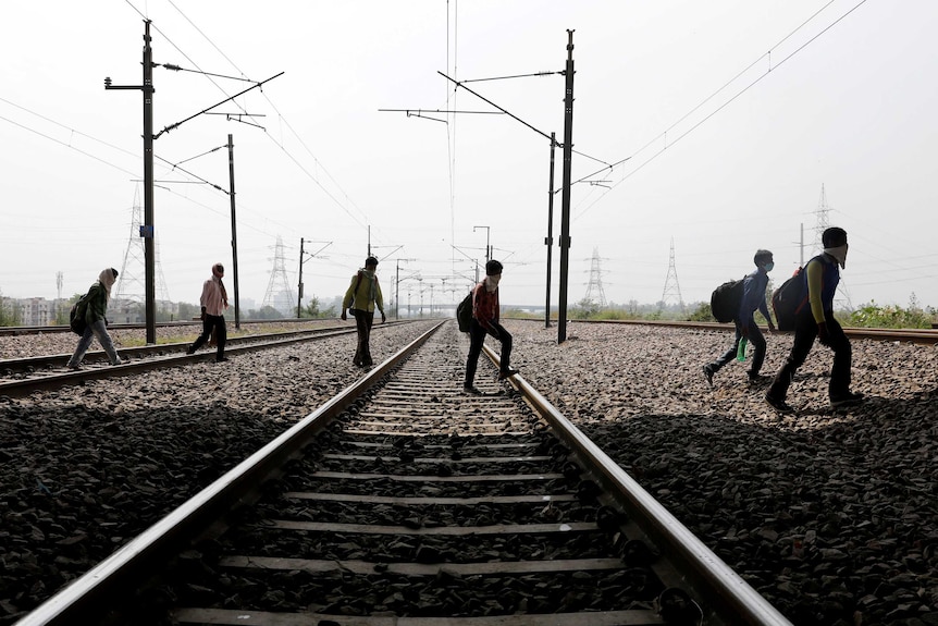 Men walk across a railway line.