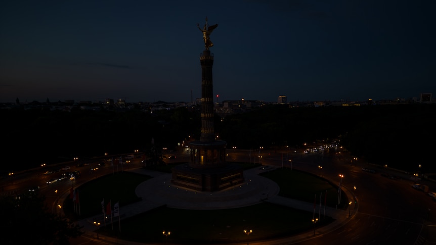 Berlin's victory column with golden angel on top in the semi-darkness 