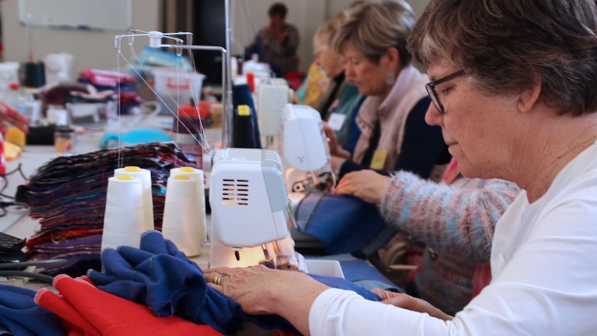 A row of women working at sewing machines.