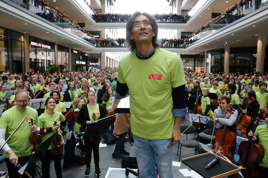 US conductor Kent Nagano stands in front of 930 musicians in the Mall of Berlin.