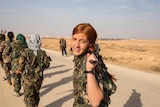 Arab girls walks with colleagues as they start a training session where they join with the Syrian Democratic Forces