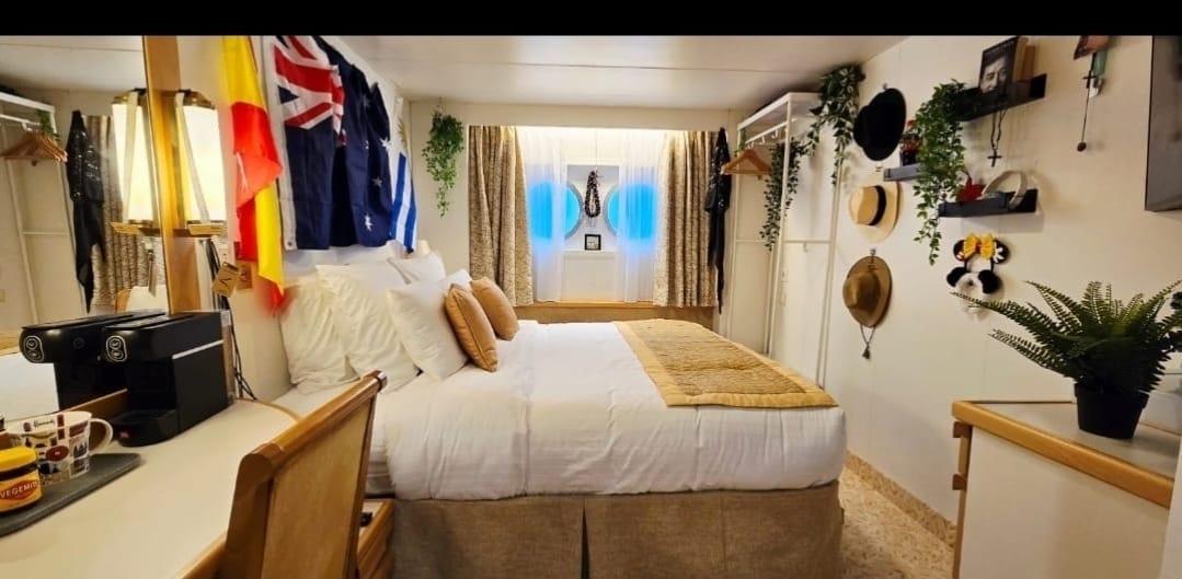 A cabin on a boat full of personal belongings.