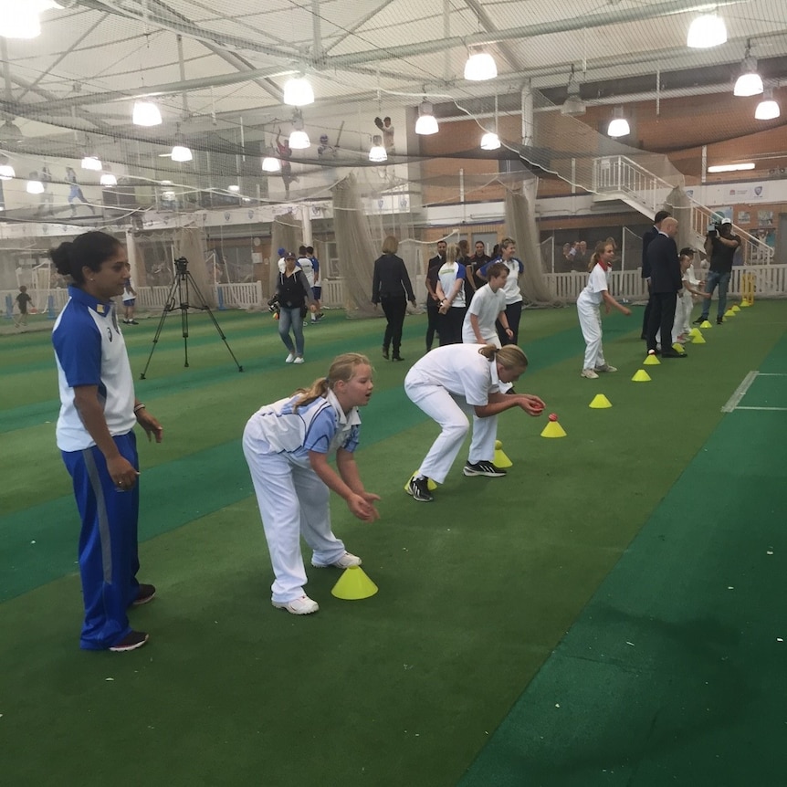 Young girls play indoor cricket