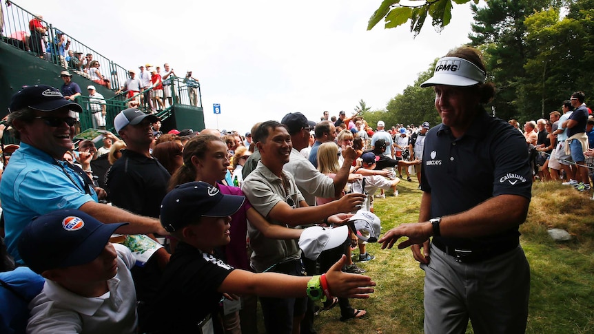 Phil Mickelson greets fans during the first round of the PGA Tour playoff event at TPC Boston.