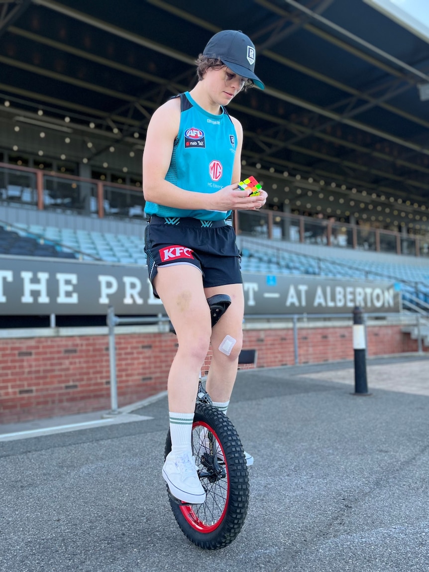 Ebony O'Dea completes a Rubik's cube while balanced on her unicycle