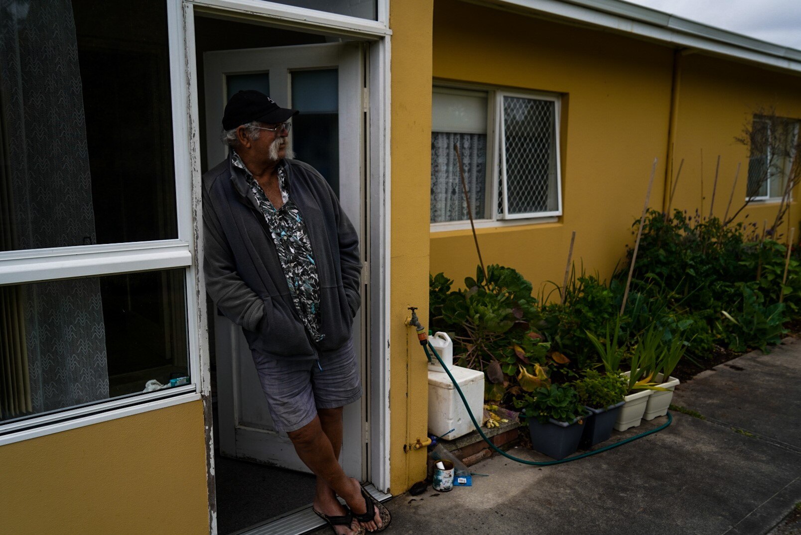 man staring over garden 