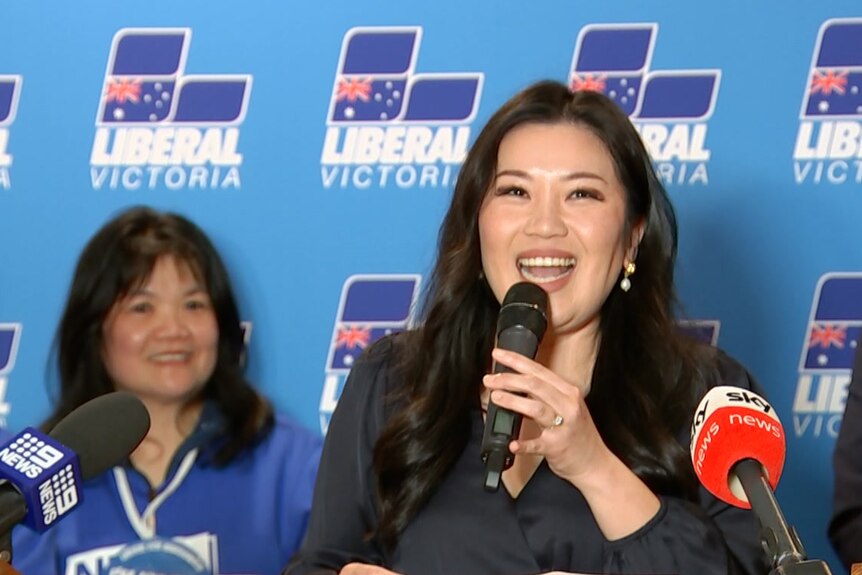 Nicole Werner smiles, holding a microphone as she addresses a Liberal Party function.