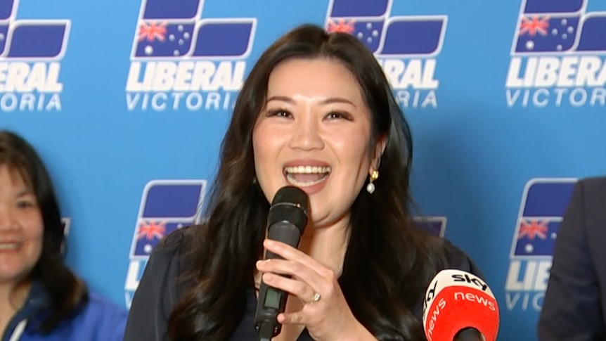 Nicole Werner smiles, holding a microphone as she addresses a Liberal Party function.