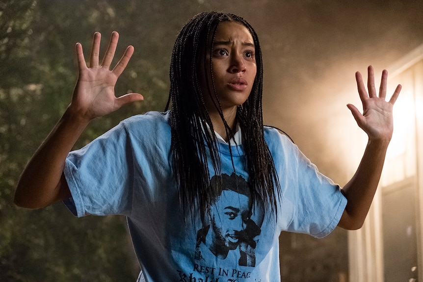 Colour still of Amandla Stenberg looking scared with arms raised in 2018 film The Hate U Give.