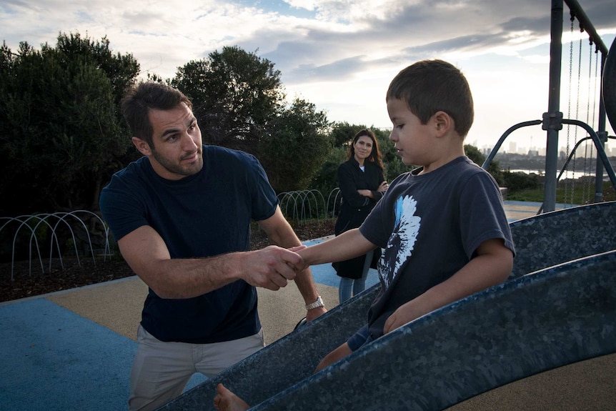 Josh Kennedy helps his son Emilio down a slide.