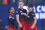Ellyse Perry celebrates a WPL wicket with RCB teammates.