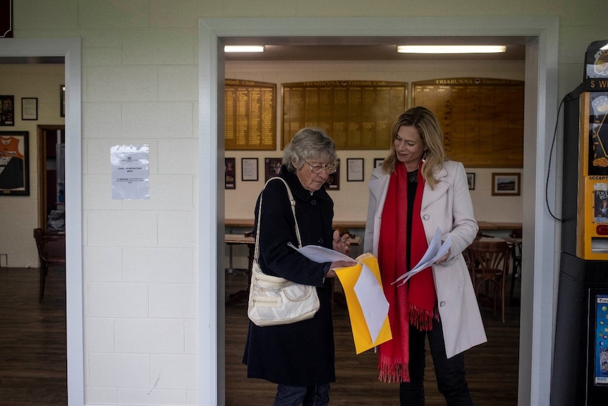 A middle aged woman talking to an elderly woman.