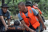 Philippine police rescuers use a rubber boat to evacuate a resident after flash floods brought by Typhoon Washi.