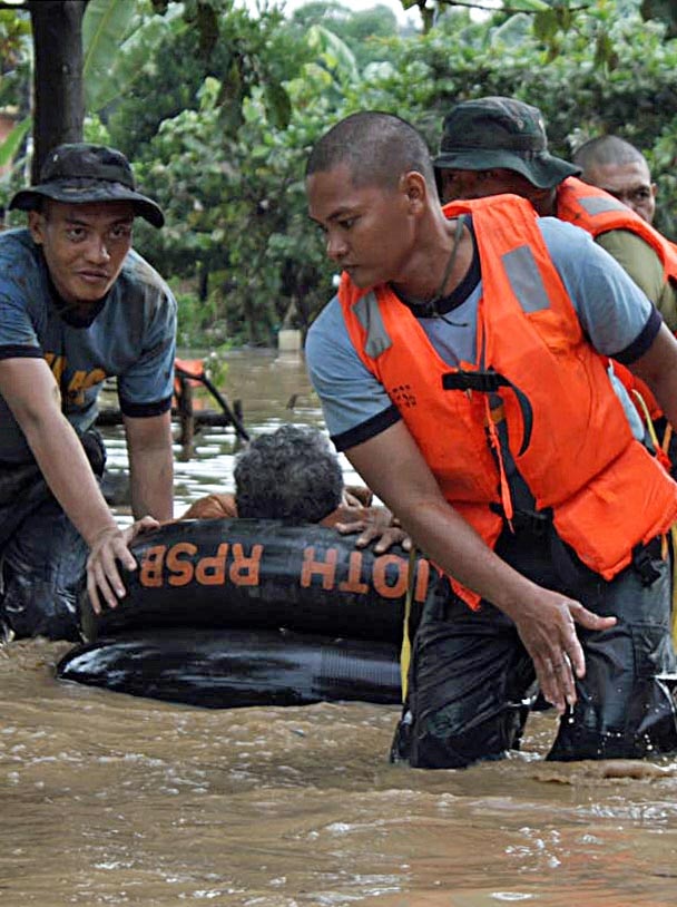 Philippine police rescuers use a rubber boat to evacuate a resident after flash floods brought by Typhoon Washi.