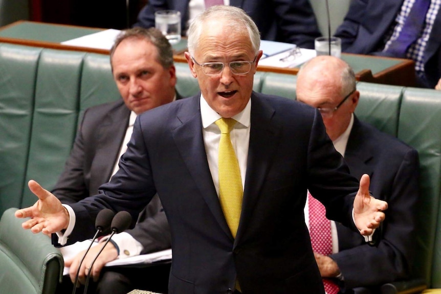 Elevated view of Malcolm Turnbull gesturing with both hands as he speaks in the House of Representatives Chamber.