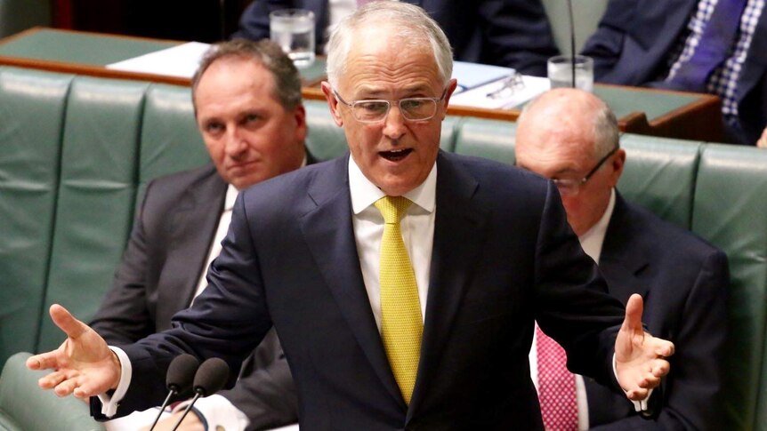 Elevated view of Malcolm Turnbull gesturing with both hands as he speaks in the House of Representatives Chamber.