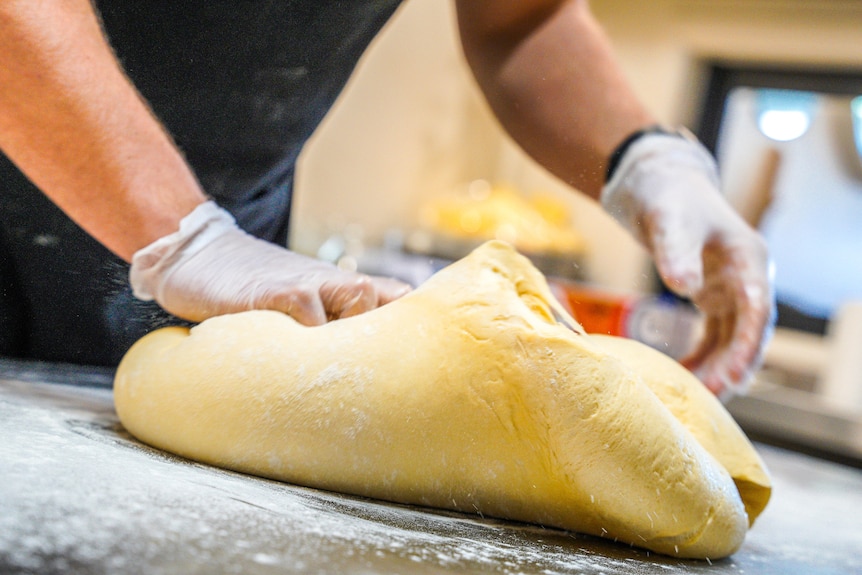 Baker kneading dough to make bread