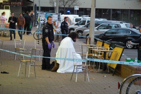 A police car and tape at Ainslie shops at night.