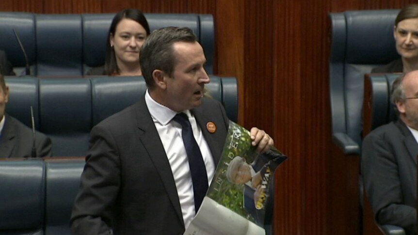 Mark McGowan holds up a magazine while speaking in Parliament.