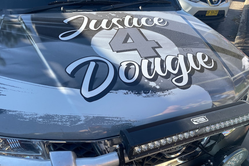 A car with "Justice 4 Dougie" painted on the bonnet.
