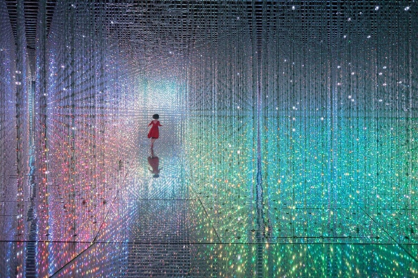 A girl is seen running among lights at an art exhibition