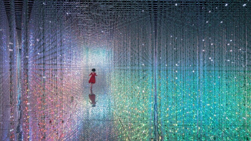 A girl is seen running among lights at an art exhibition