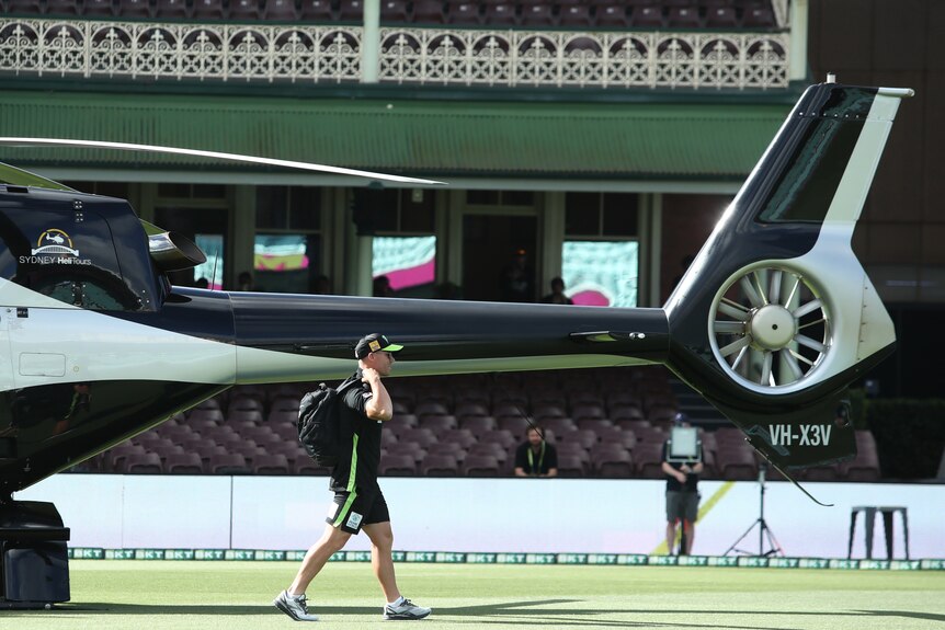 David Warner walking away from a helicopter that delivered him to the Sydney Cricket Ground for a Sydney Thunder BBL game.