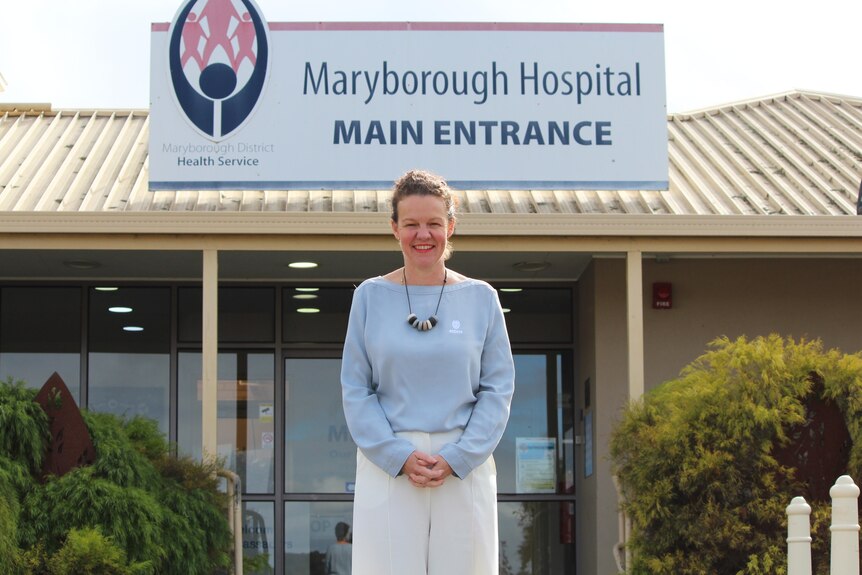 A woman stands in front of Maryborough Hospital main entrance. 