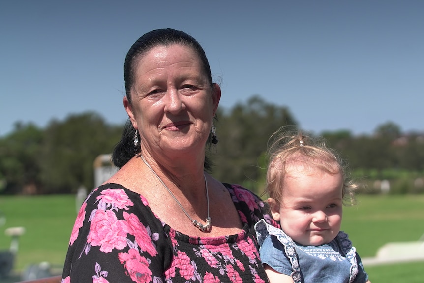 Older woman holding a young toddler.