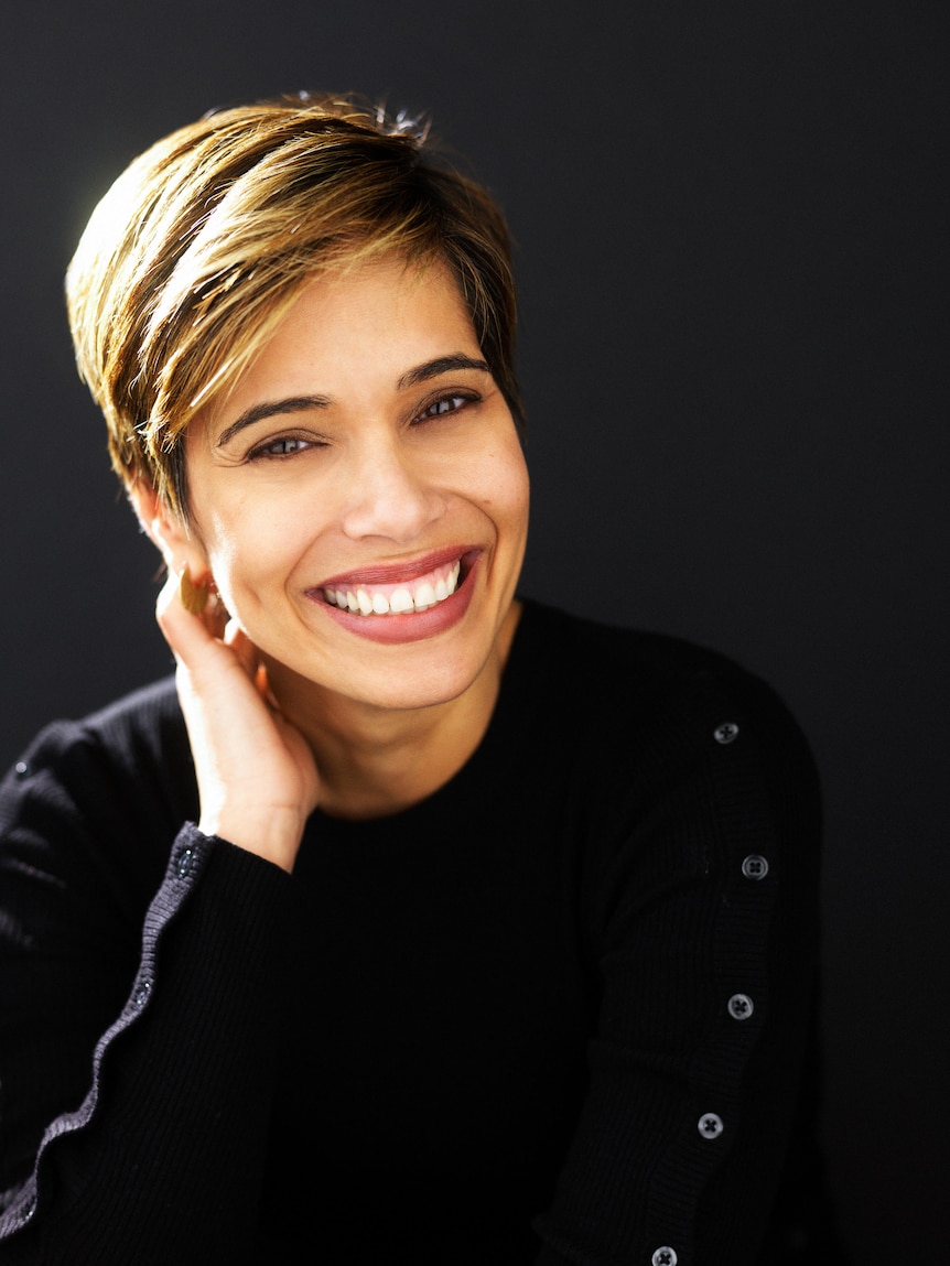 Portrait of a middle-aged woman with a broad smile and short dark blonde hair.