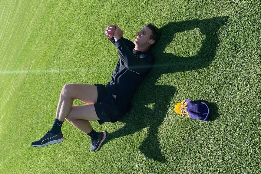 A footballer training on a green sports oval.