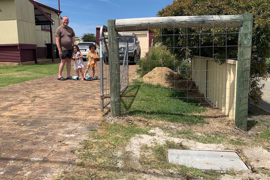 Sean Kelly standing in his driveway with kids.