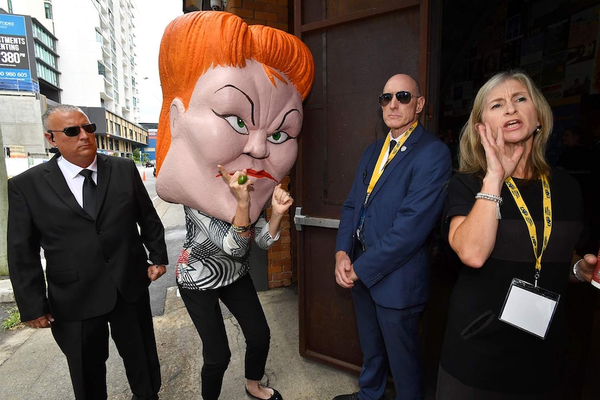 A protestor wearing a mask depicting Pauline Hanson is seen outside the LNP campaign launch on November 19, 2017.