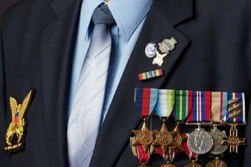 An elderly man in a naval cap with his service medals