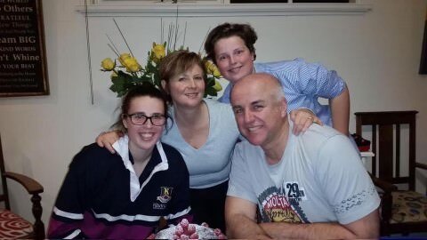 A family of four together sitting at a table.