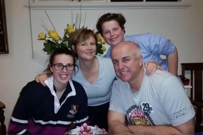 A family of four together sitting at a table.