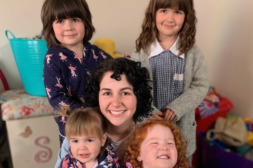 Melissa McDowell and her four daughters smile at the camera.